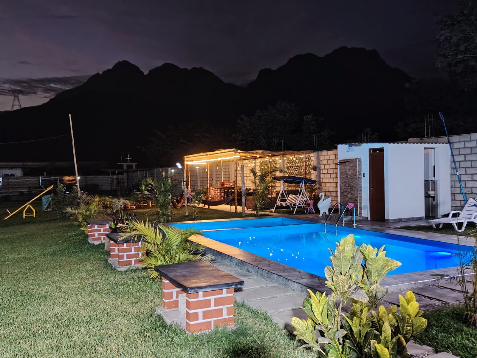 Vista nocturna de la piscina iluminada